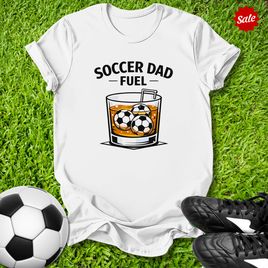 White t-shirt with 'Soccer Dad Fuel' graphic on grass with soccer ball and cleats