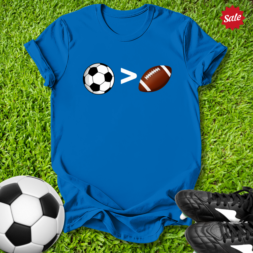 Blue t-shirt with sports ball design on grass with soccer ball and shoes