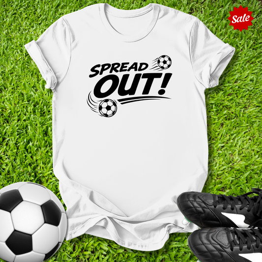 White t-shirt with 'Spread Out!' text on grass with soccer ball and shoes