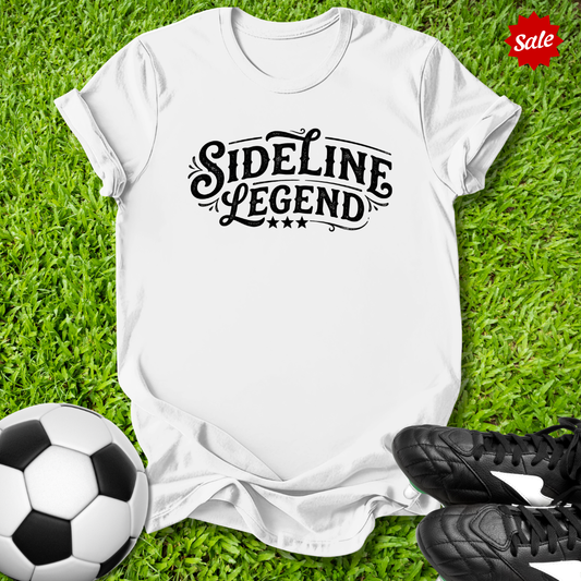 White t-shirt with 'Sideline Legend' text on grass with soccer ball and shoes