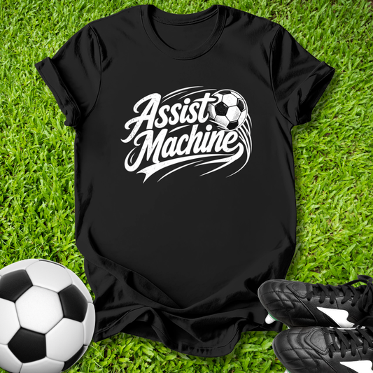 Black t-shirt with 'Assist Machine' text on grass with soccer ball and shoes