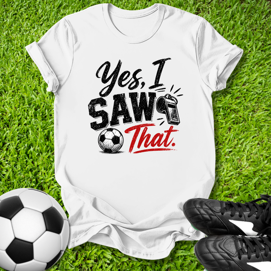 White t-shirt with 'Yes, I Saw That' text on grass with soccer ball and shoes
