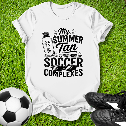 White t-shirt with black text on grass with soccer ball and shoes