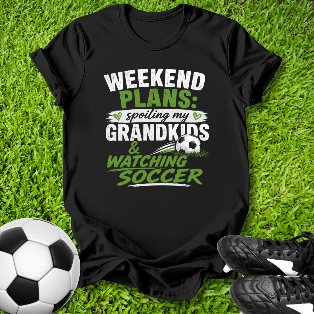 Black t-shirt with 'Weekend Plans' text on grass with soccer ball and shoes