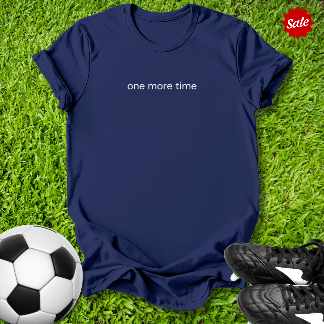Navy blue t-shirt with 'one more time' text on grass with soccer ball and shoes
