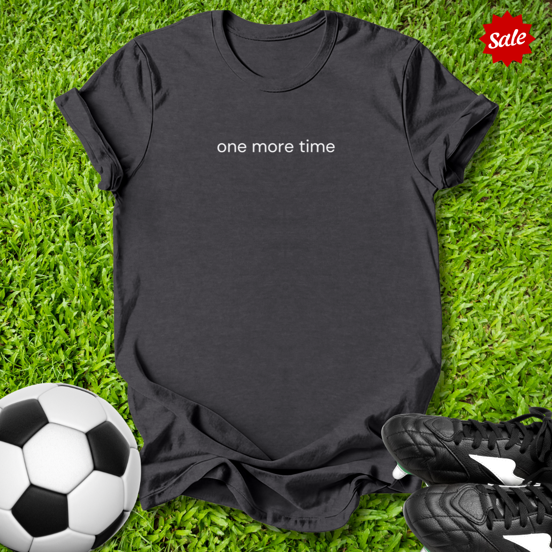 Black t-shirt with 'one more time' text on grass with soccer ball and shoes