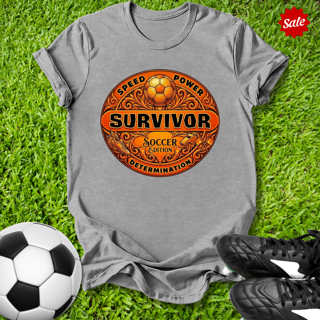 Gray t-shirt with Survivor soccer-themed design on grass with soccer ball and shoes