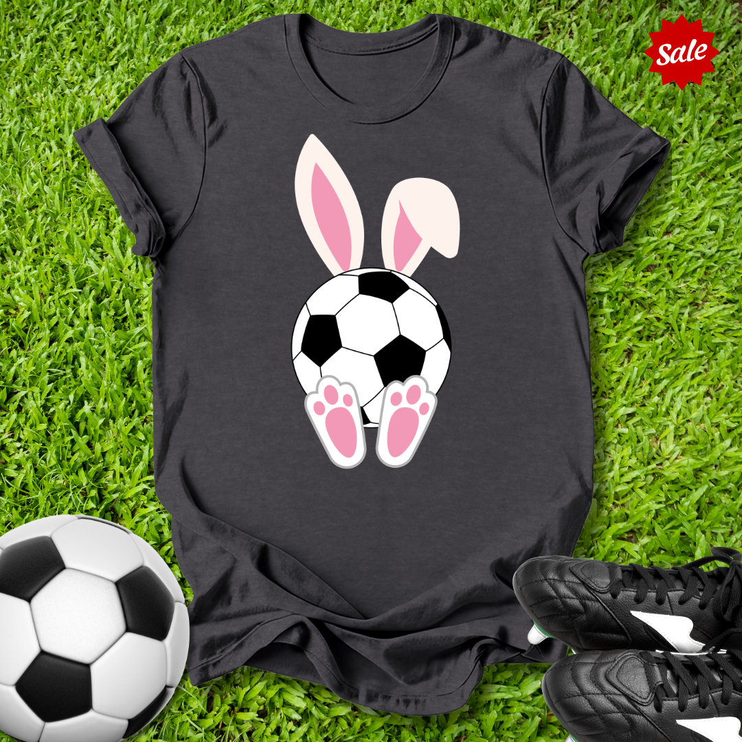 Black t-shirt with soccer ball and  Easter bunny ears design on grass with soccer ball and shoes.
