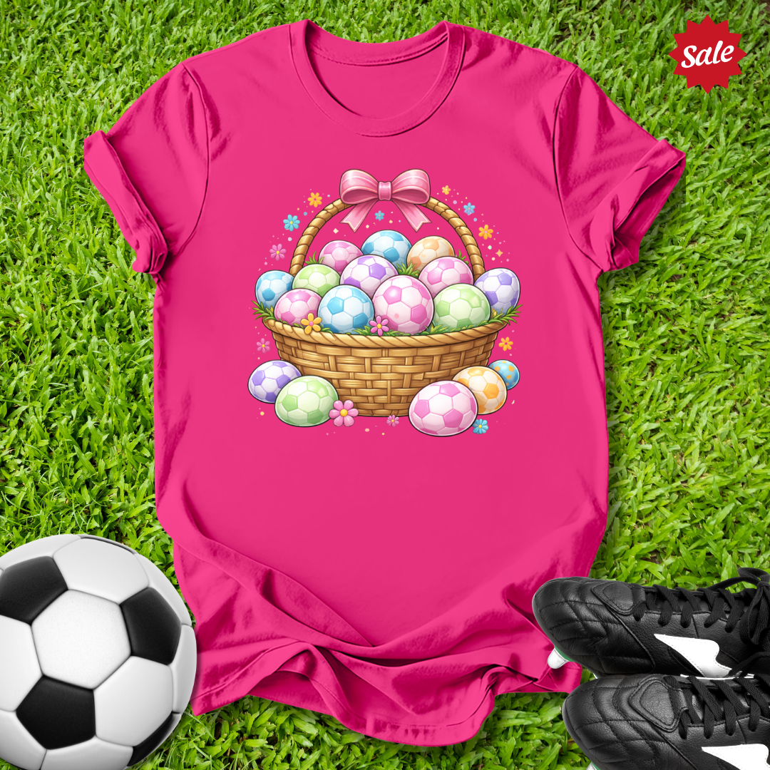 Pink t-shirt with Easter egg design on grass with soccer ball and shoes