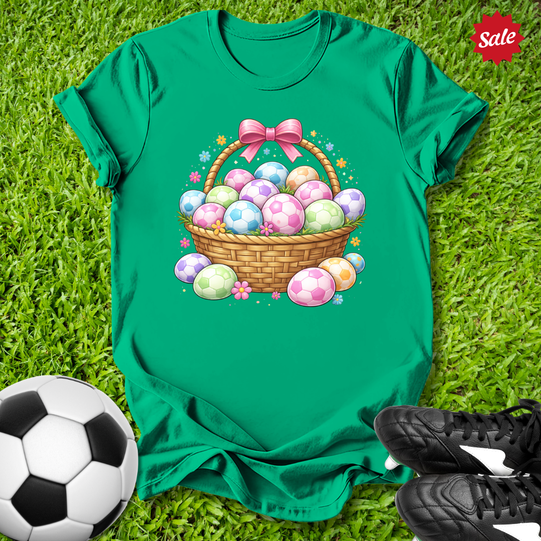 Green t-shirt with Easter egg basket design on grass with soccer ball and shoes