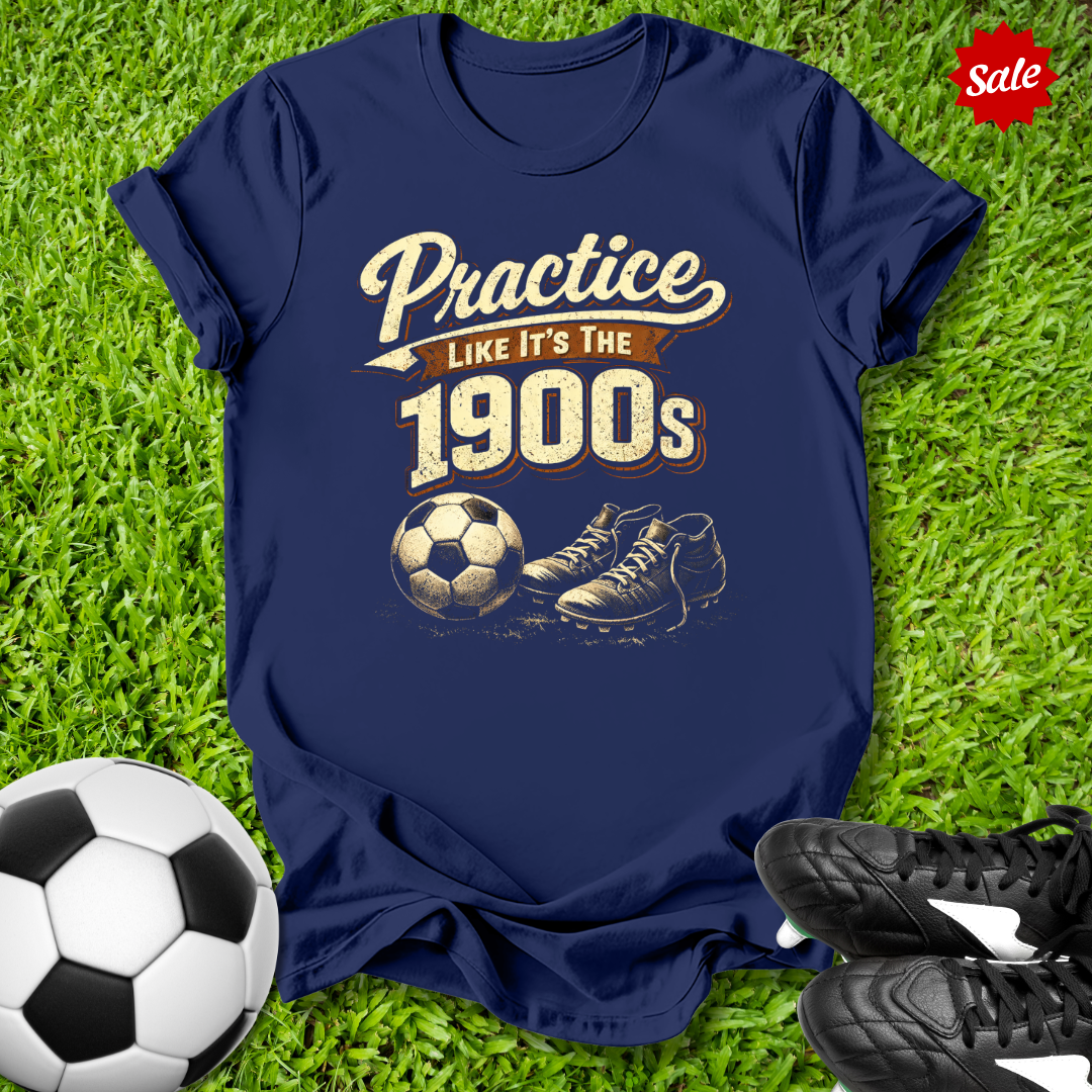 Navy blue t-shirt with sports-themed design on grass with soccer ball and shoes