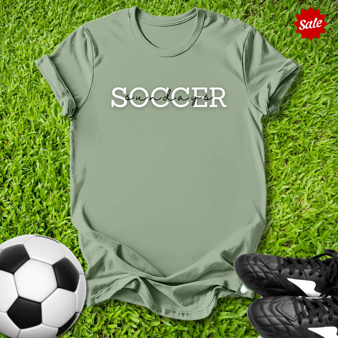 Green t-shirt with 'Soccer Sundays' text on grass with soccer ball and shoes