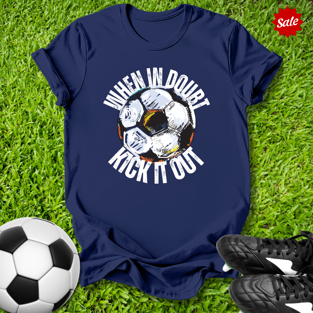 Navy blue t-shirt with  when in doubt kick it out soccer graphic and text on grass with soccer ball and shoes