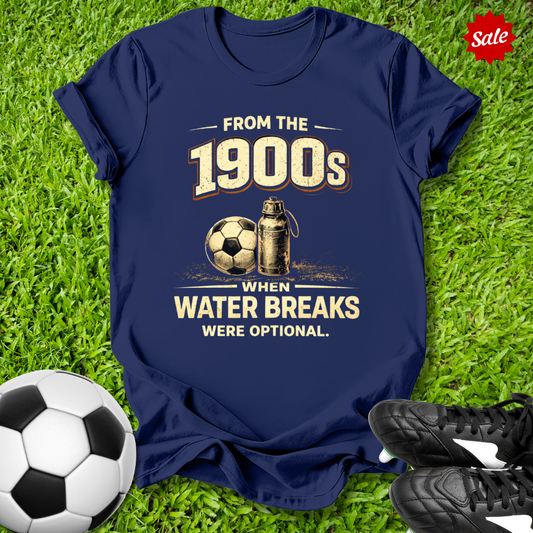 Navy blue t-shirt with vintage soccer design with from the 1900s when water breaks were optional on grass  text with soccer ball and shoes.