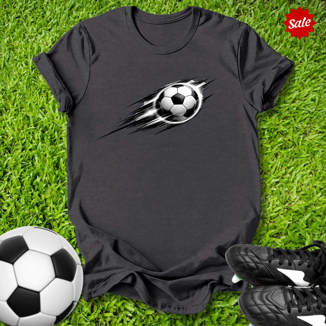 Black t-shirt with soccer ball design on grass with soccer ball and shoes