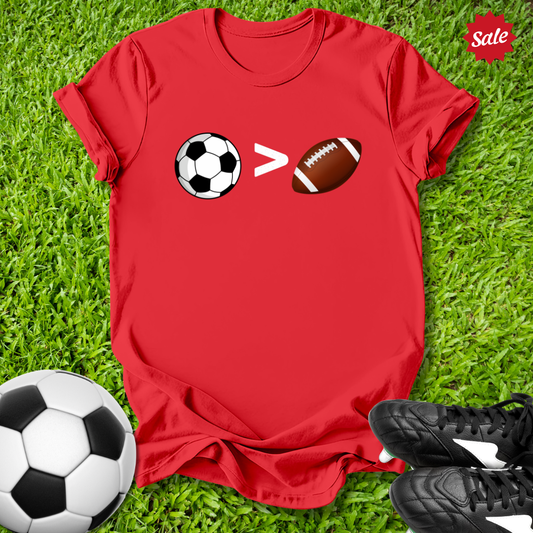 Red t-shirt with sports ball design on grass with soccer ball and shoes