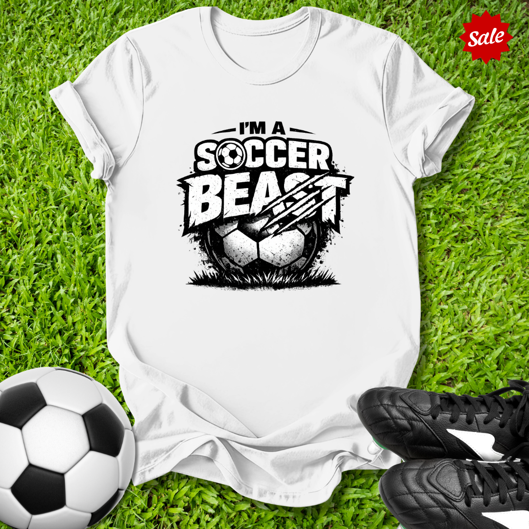 White t-shirt with 'Soccer Beast' graphic on grass with soccer ball and shoes