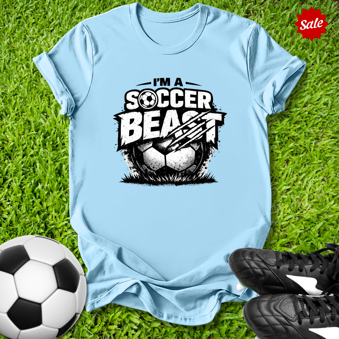 Light blue t-shirt with 'Soccer Beast' graphic on grass with soccer ball and shoes.