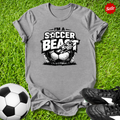 Gray t-shirt with 'Soccer Beast' graphic on grass with soccer ball and shoes