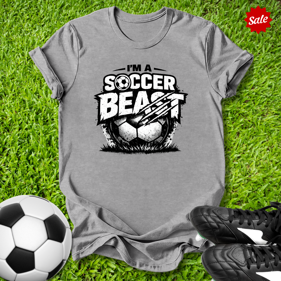 Gray t-shirt with 'Soccer Beast' graphic on grass with soccer ball and shoes