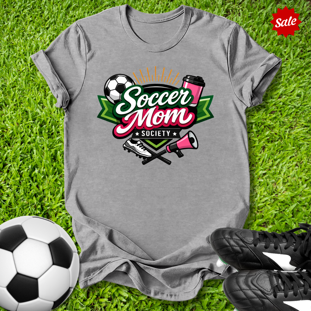Gray t-shirt with 'Soccer Mom Society' design on grass with soccer ball and shoes.