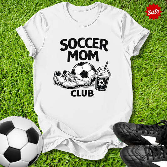 White Pink t-shirt with 'Soccer Mom Club' text on grass with soccer ball and shoes