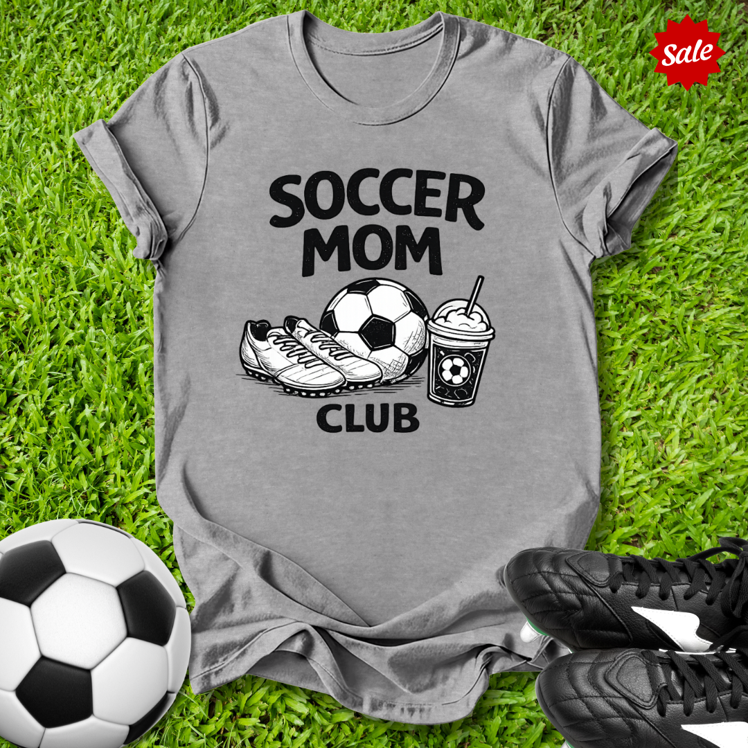 Gray Pink t-shirt with 'Soccer Mom Club' text on grass with soccer ball and shoes