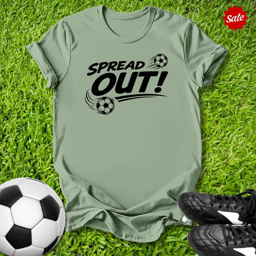 Sage green t-shirt with 'Spread Out!' text on grass with soccer ball and shoes