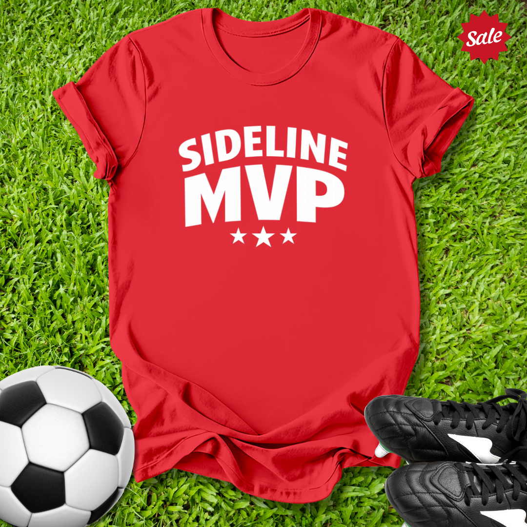 Red t-shirt with 'Sideline MVP' text on grass with soccer ball and shoes