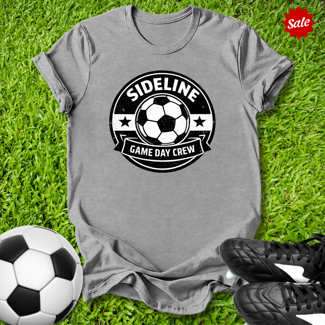 Gray t-shirt with 'Sideline Game Day Crew' design on grass with soccer ball and shoes.