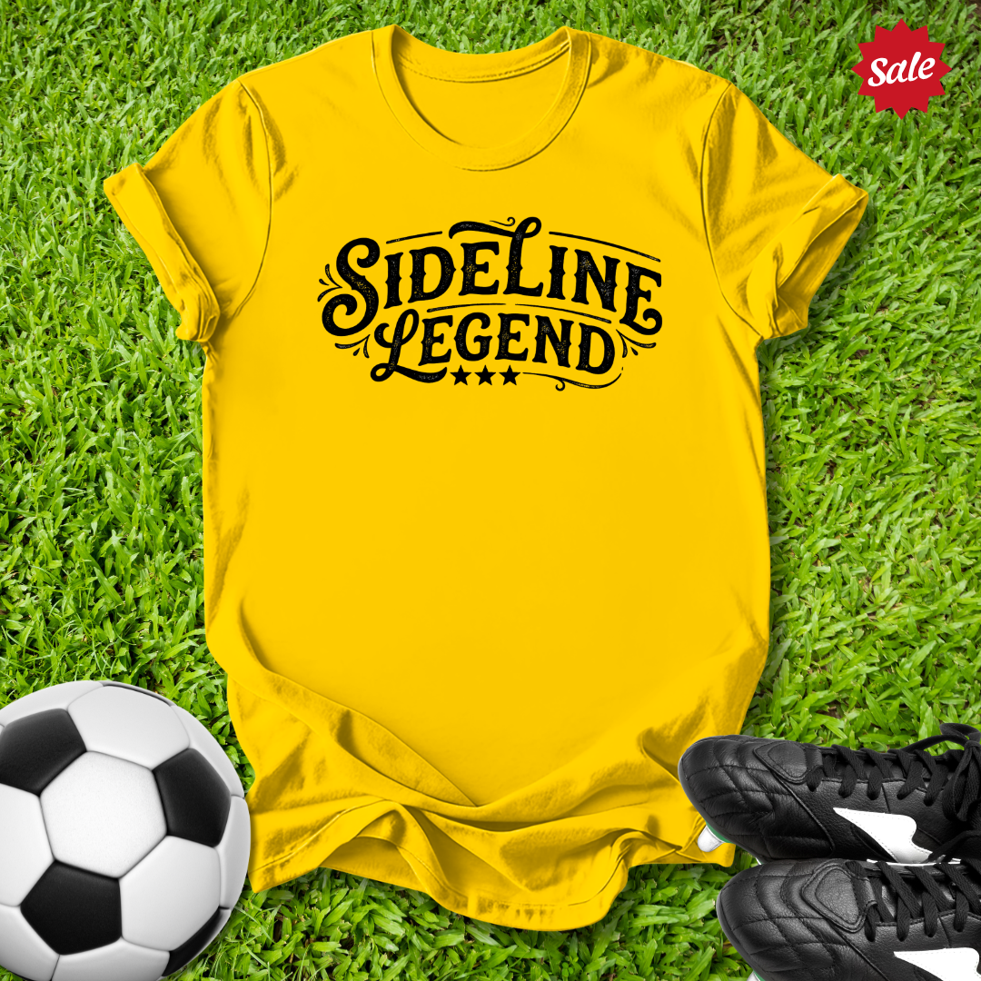 Yellow t-shirt with 'Sideline Legend' text on grass with soccer ball and shoes