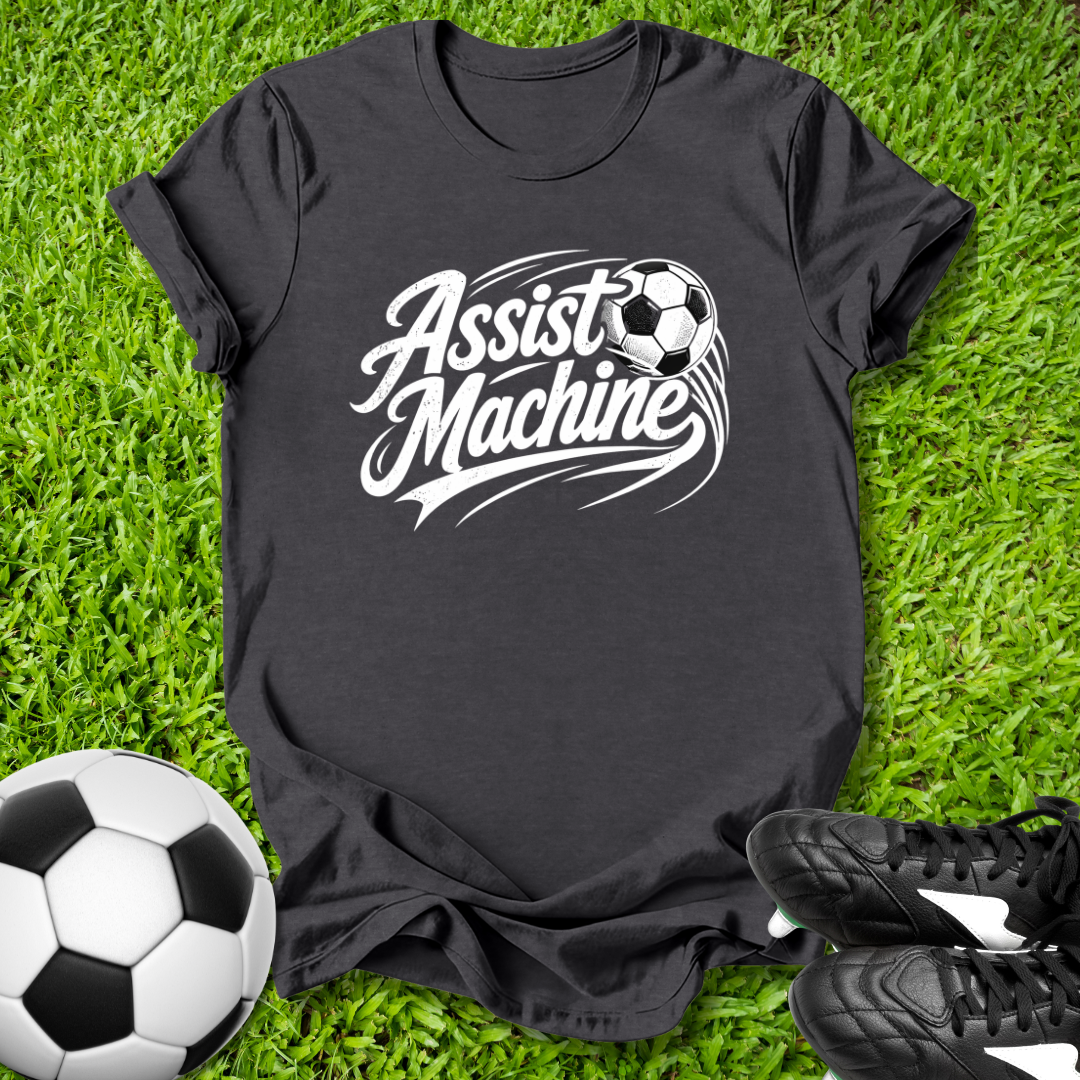 Black t-shirt with 'Assist Machine' graphic on grass with soccer ball and shoes