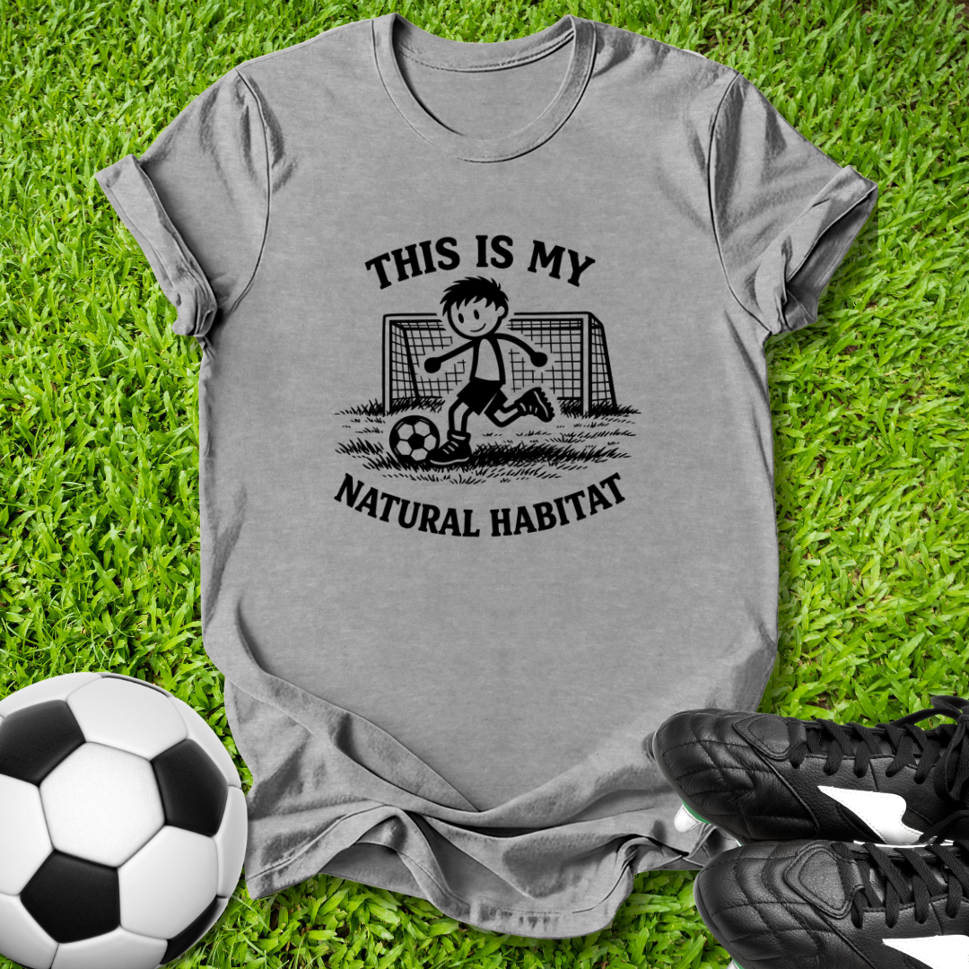 Gray t-shirt with soccer graphic and  this is my natural habitat text on grass with soccer ball and shoes