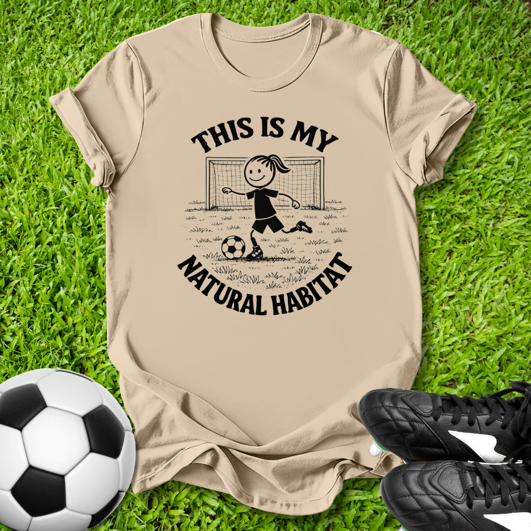 Beige t-shirt with soccer graphic  this is my natural habitat and text on grass with soccer ball and shoes