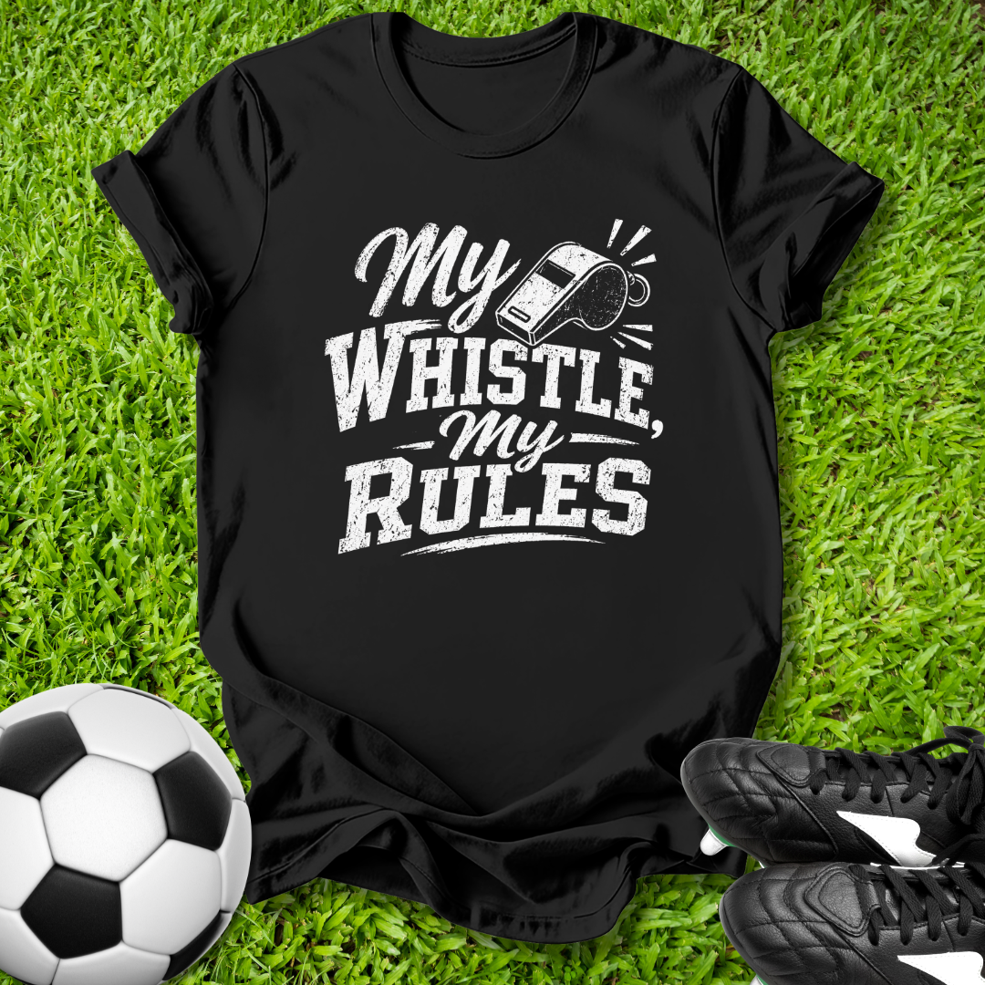 Black t-shirt with 'My Whistle, My Rules' text on grass with soccer ball and shoes.