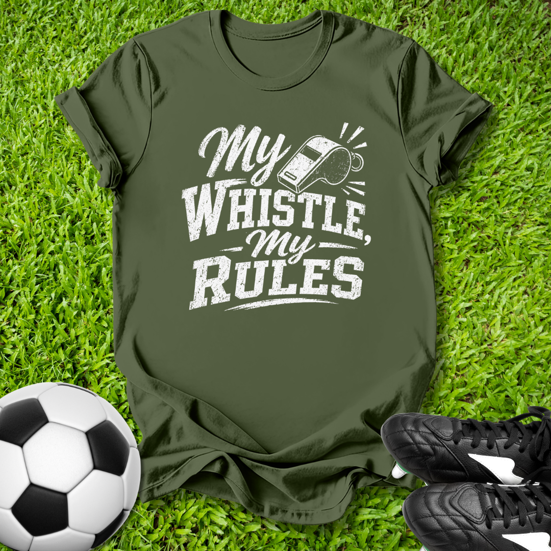 Green t-shirt with 'My Whistle, My Rules' text on grass with soccer ball and shoes.