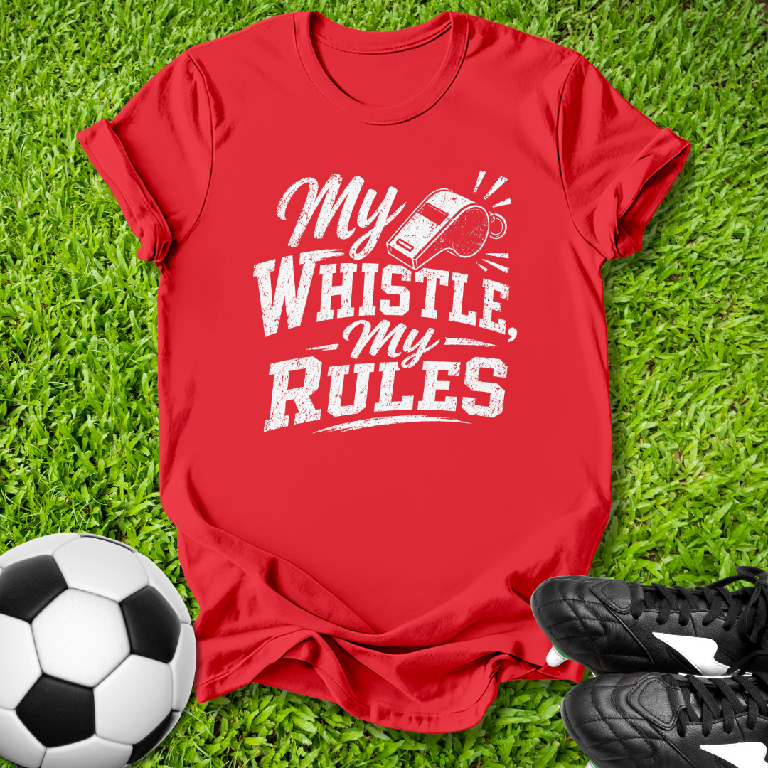Red t-shirt with 'My Whistle My Rules' text on grass with soccer ball and shoes