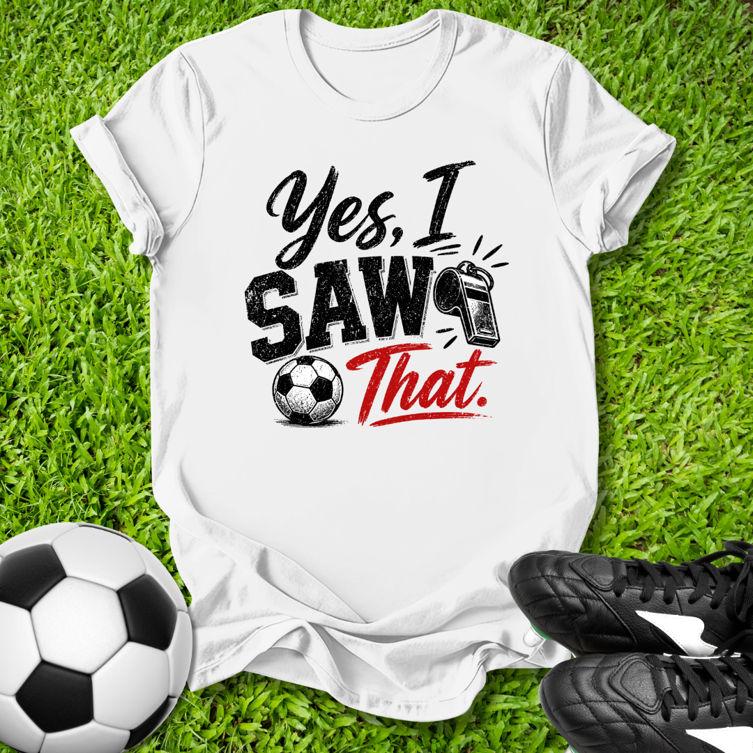 White t-shirt with 'Yes, I Saw That' text on grass with soccer ball and shoes