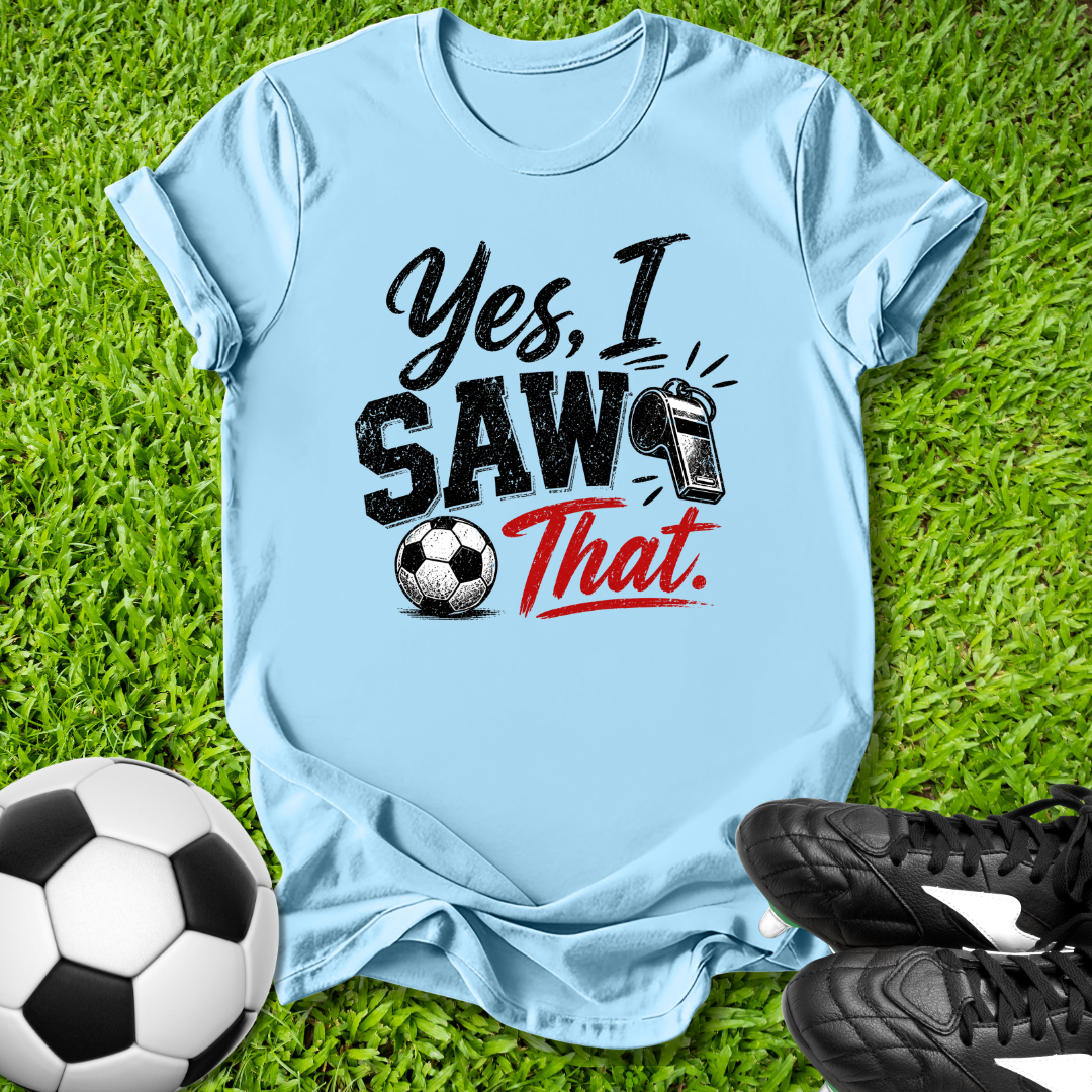 Light blue t-shirt with 'Yes, I Saw That' text on grass with soccer ball and shoes
