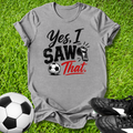 Gray t-shirt with 'Yes, I Saw That' text on grass with soccer ball and shoes