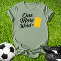 Green t-shirt with 'One More Word' text on grass with soccer ball and shoes
