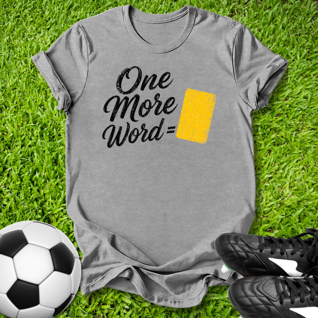 Gray t-shirt with 'One More Word' text on grass with soccer ball and shoes