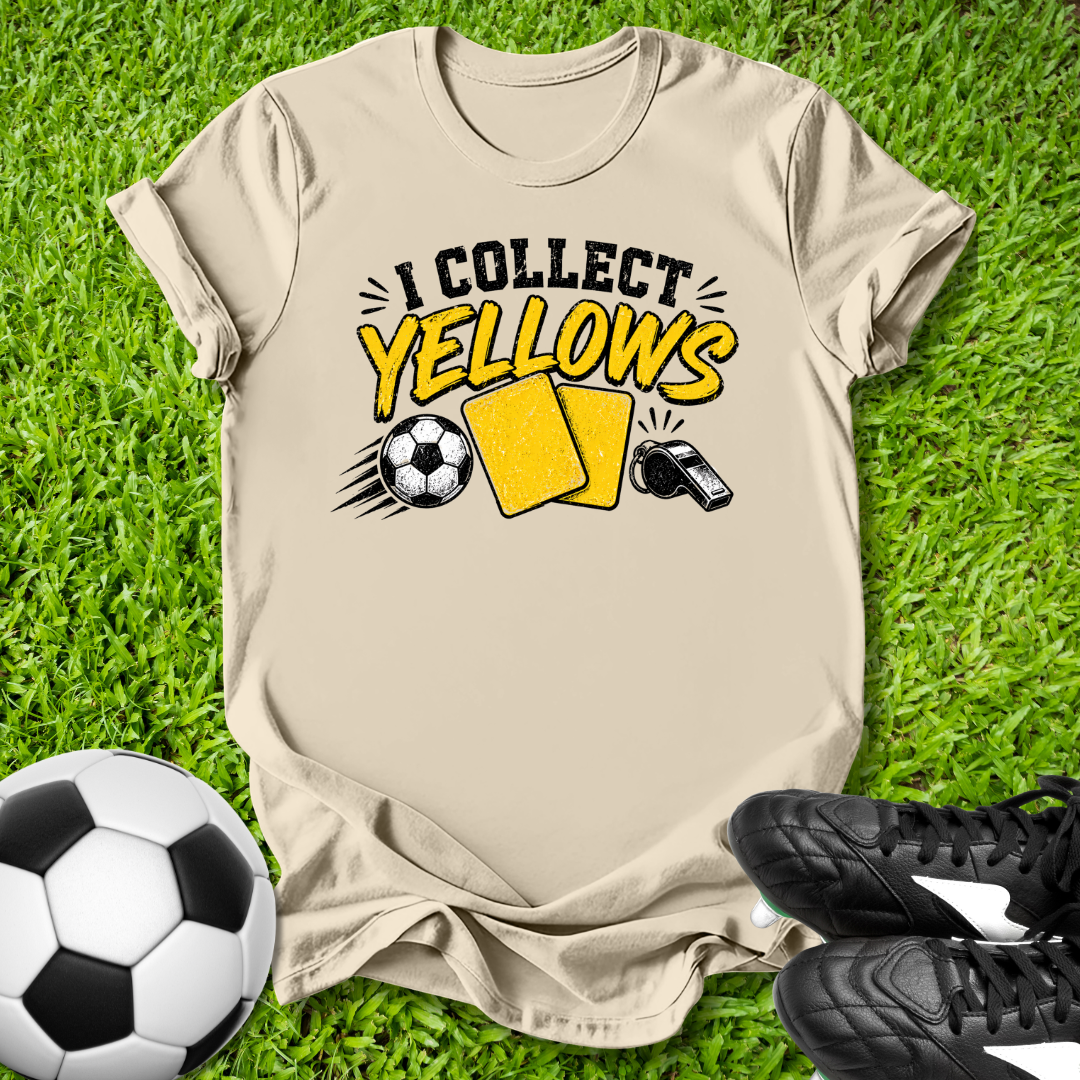 Beige t-shirt with 'I Collect yellows' text and soccer ball graphics on grass with soccer ball and shoes.