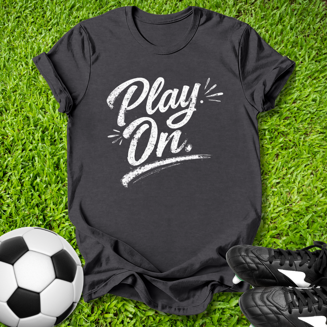 Black t-shirt with 'Play On' text on grass with soccer ball and shoes