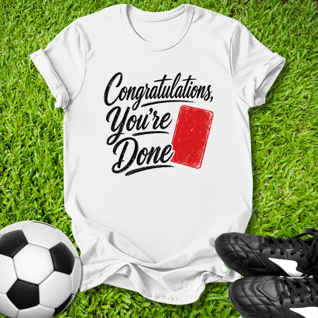White t-shirt with 'Congratulations, You're Done' text and red card on grass with soccer ball and shoes.