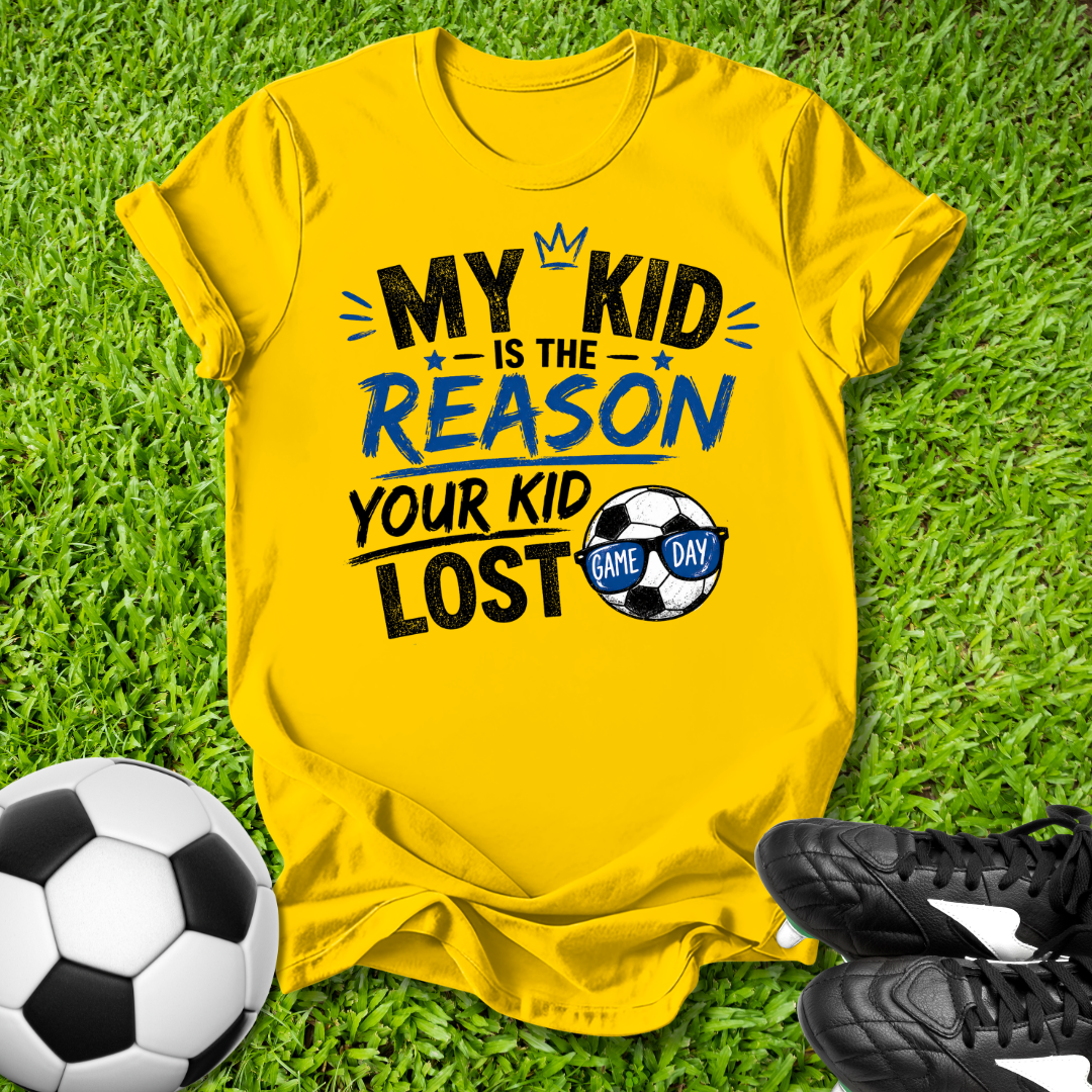 Yellow  t-shirt with humorous My Kid is the Reason Your Kid Lost text soccer-themed text on grass with soccer ball and shoes.