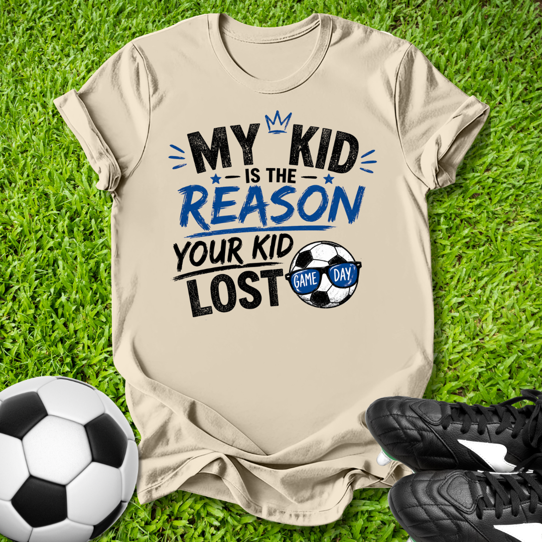 Natural  t-shirt with humorous My Kid is the Reason Your Kid Lost text soccer-themed text on grass with soccer ball and shoes.