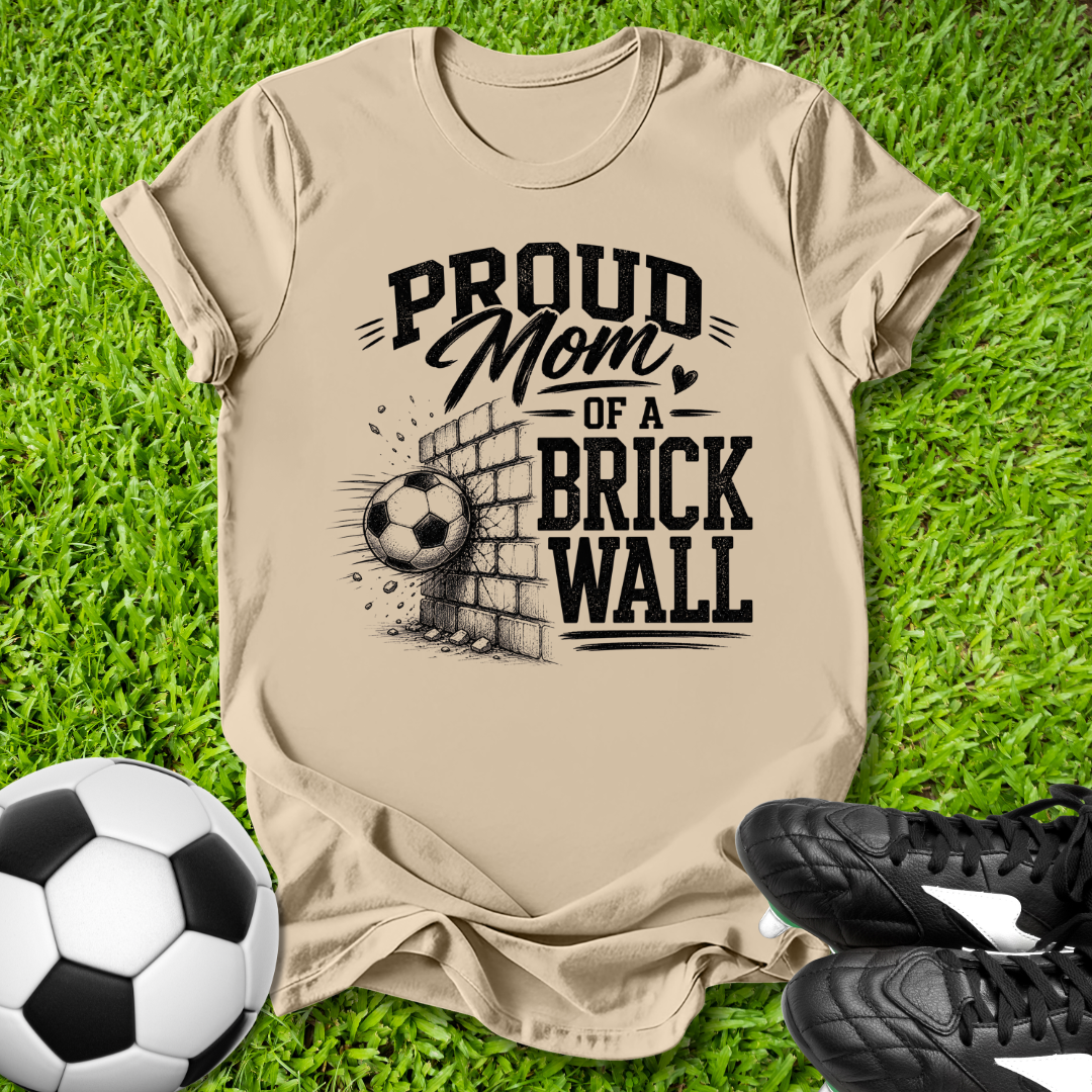 Tan shirt with a soccer ball that says in white text Proud Soccer Mom of a Brick Wall