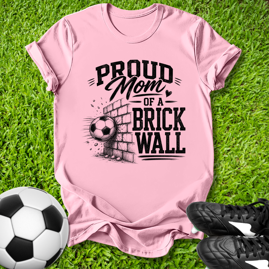 Pink shirt with a soccer ball that says in white text Proud Soccer Mom of a Brick Wall