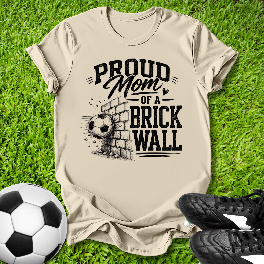 Beige shirt with a soccer ball that says in white text Proud Soccer Mom of a Brick Wall